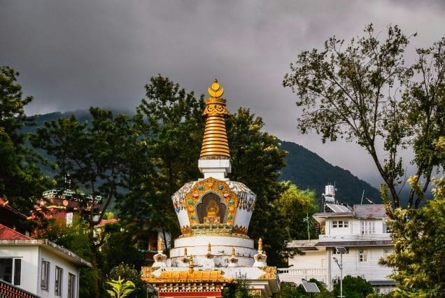 Buddhist stupa in mcleodganj and dharamshala surrounded by hills and homes