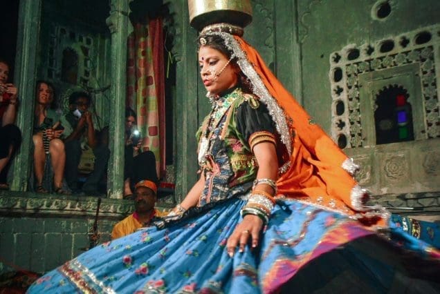 Rajasthani folk dancer balancing pot indoors — jaipur to udaipur journey