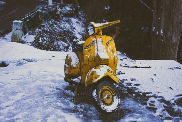 Snow-covered yellow scooter on a winter road during Dalhousie trip