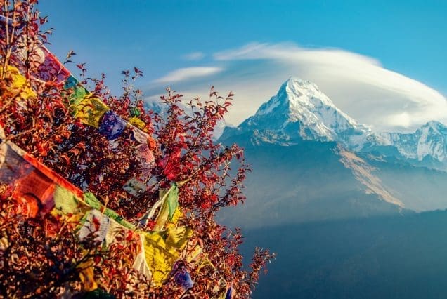 Snow-capped Himalayan peak with prayer flags — Guwahati to Kaziranga route